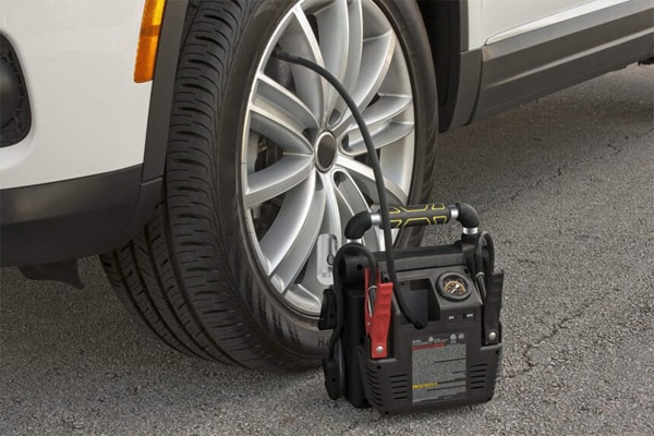 A jump starter with an air compressor to help inflate tires with low pressure